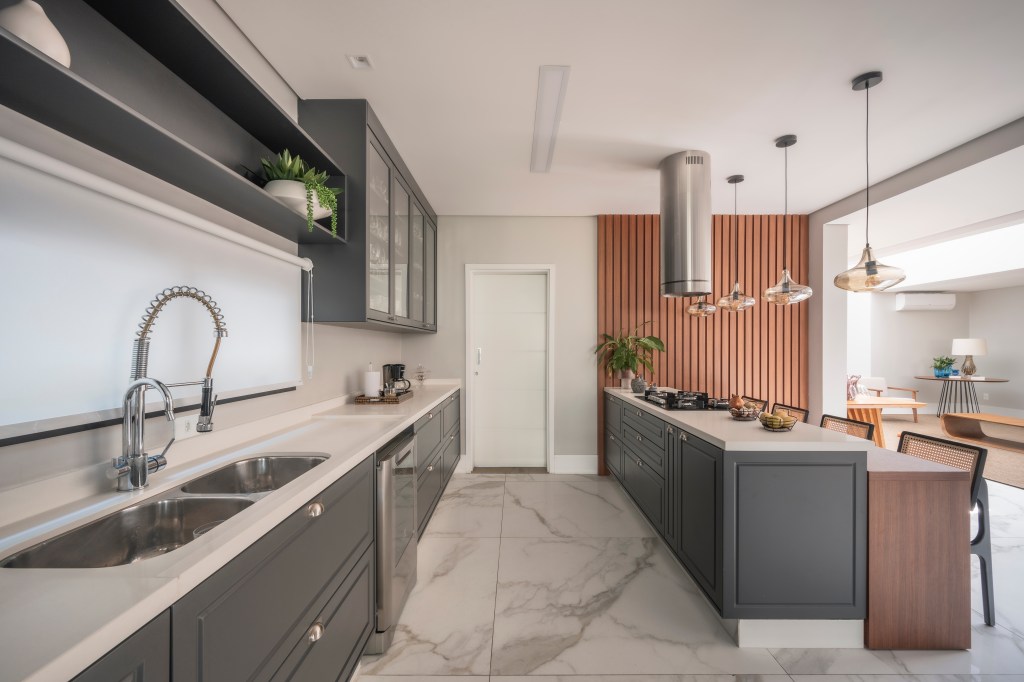 Com 500 m², casa clean tem paleta clara, closet e cozinha provençal. Projeto de PB Arquitetura. Na foto, cozinha provençal, armários cinzas, ilha de cozinha, piso marmorizado.