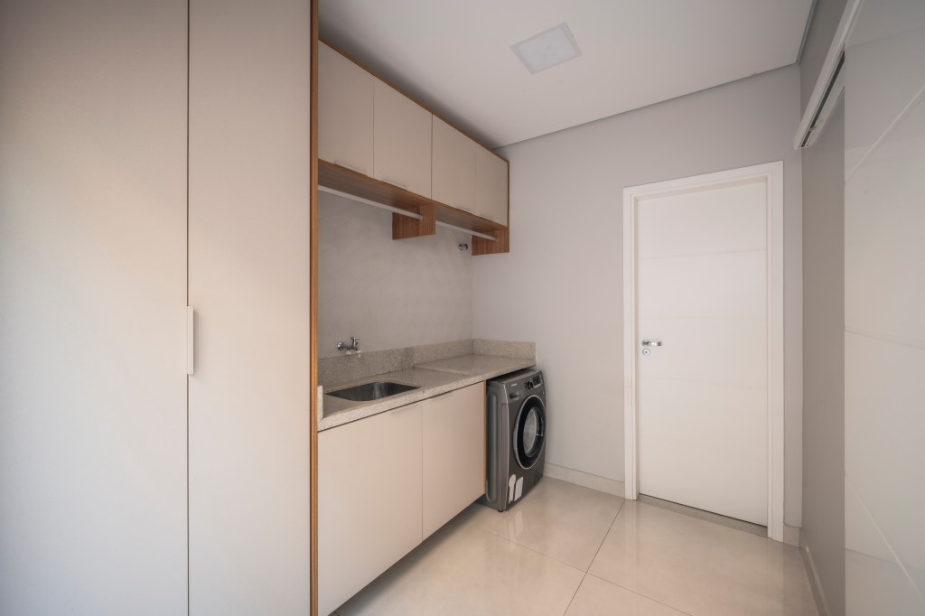 Com 500 m², casa clean tem paleta clara, closet e cozinha provençal. Projeto de PB Arquitetura. Na foto, lavanderia com marcenaria off white.
