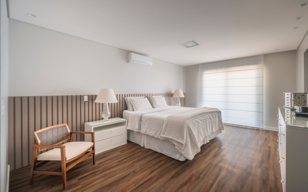 Com 500 m², casa clean tem paleta clara, closet e cozinha provençal. Projeto de PB Arquitetura. Na foto, quarto de casal, cabeceira de madeira, persiana.