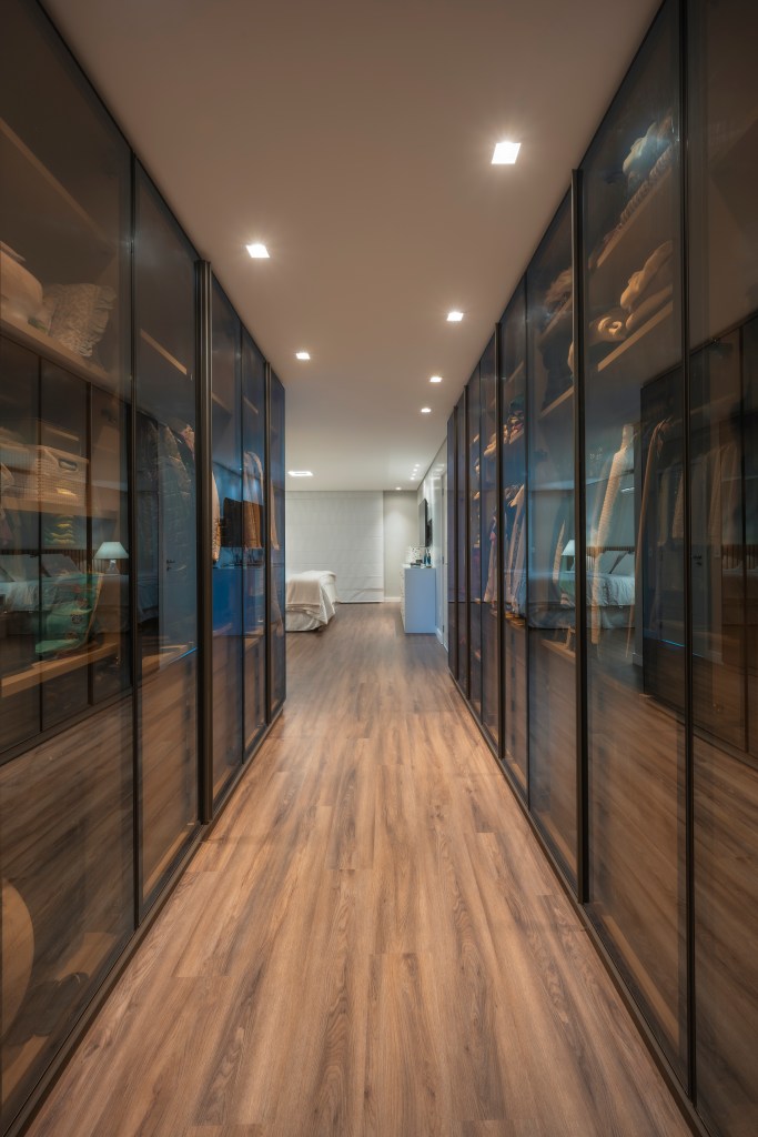 Com 500 m², casa clean tem paleta clara, closet e cozinha provençal. Projeto de PB Arquitetura. Na foto, closet grande com armários com portas de vidro.