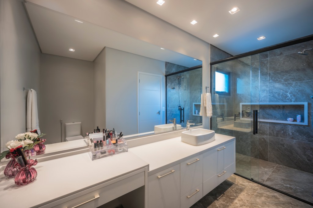Com 500 m², casa clean tem paleta clara, closet e cozinha provençal. Projeto de PB Arquitetura. Na foto, banheiro com espelho amplo.