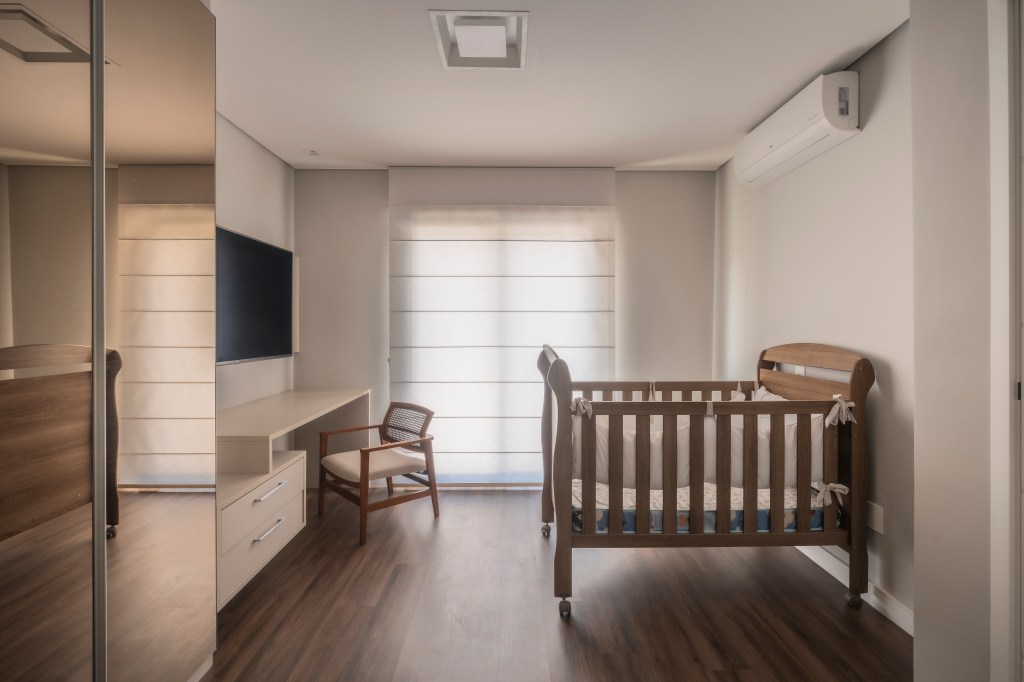 Com 500 m², casa clean tem paleta clara, closet e cozinha provençal. Projeto de PB Arquitetura. Na foto, quarto de bebê com berço, tv, persiana.