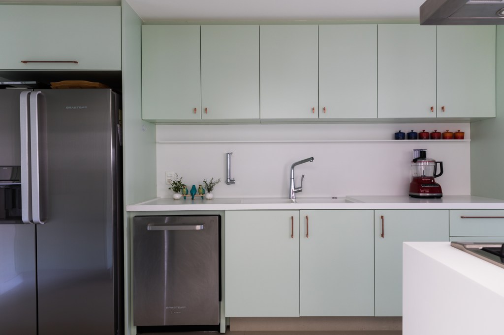 Cores diferentes criam efeitos de altura em apê com pé-direito duplo. Projeto de Caio Nazar. Na foto, cozinha com marcenaria verde.