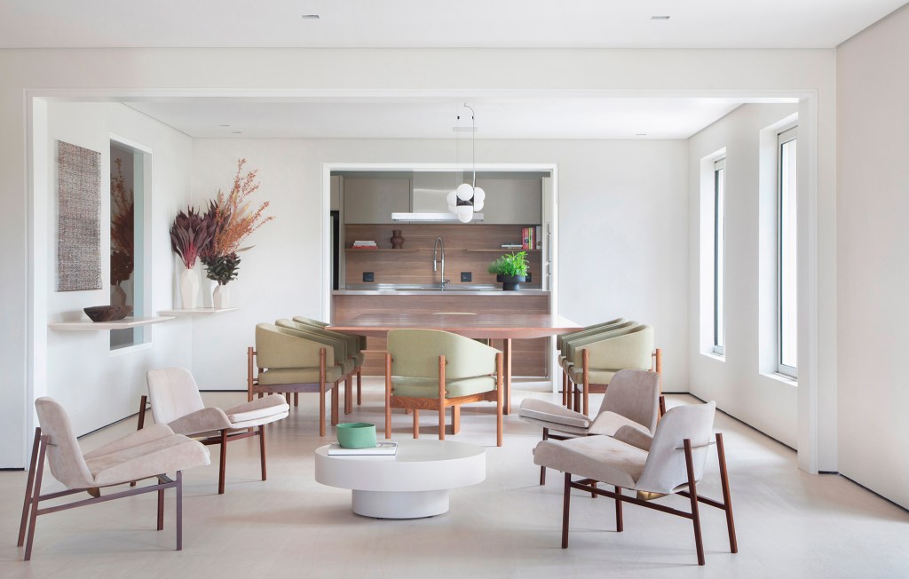 Décor minimalista, luz natural e ambientes integrados marcam apê de 350 m². Projeto de Arkitekt Associados. Na foto, sala de jantar com mesa branca e poltronas verdes,