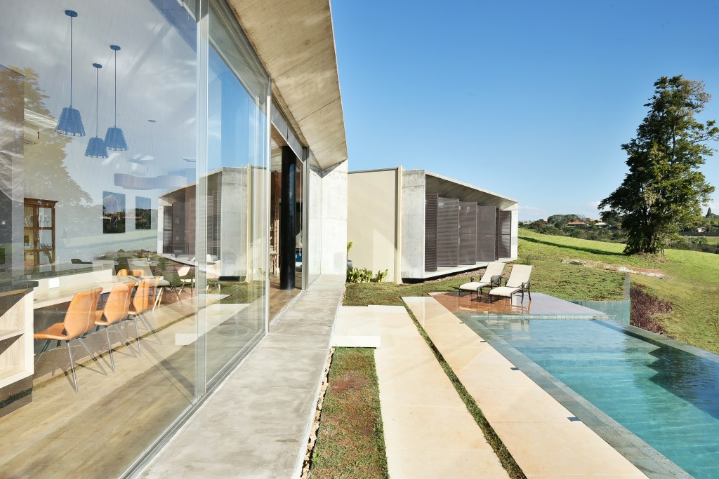 Grandes aberturas realçam o décor clean desta casa de veraneio com piscina. Projeto de Marcela Rocca. Na foto, fachada da casa e piscina.