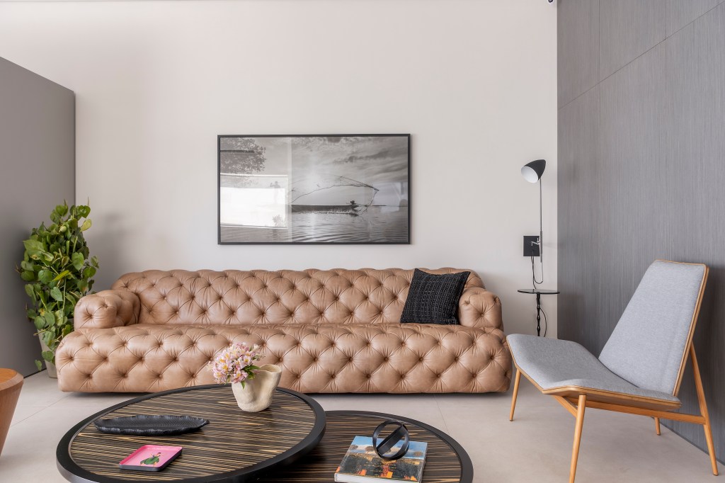 Irmãos aposentados moram cada um em cada andar desta cobertura de 342 m². Projeto Camanho Arquitetura. Na foto, sala com sofá capitonê rosa.
