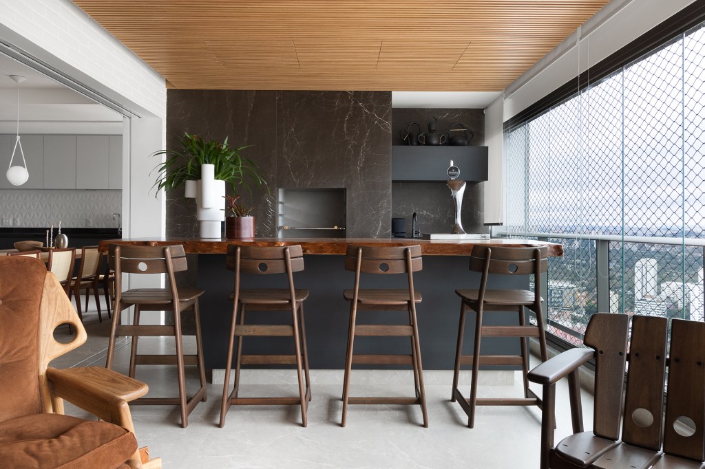 Linguagem neutra e atemporal definem o décor de apartamento de 140 m². Projeto MNBR Arquitetos. Na foto, varanda com churrasqueira e gourmet.