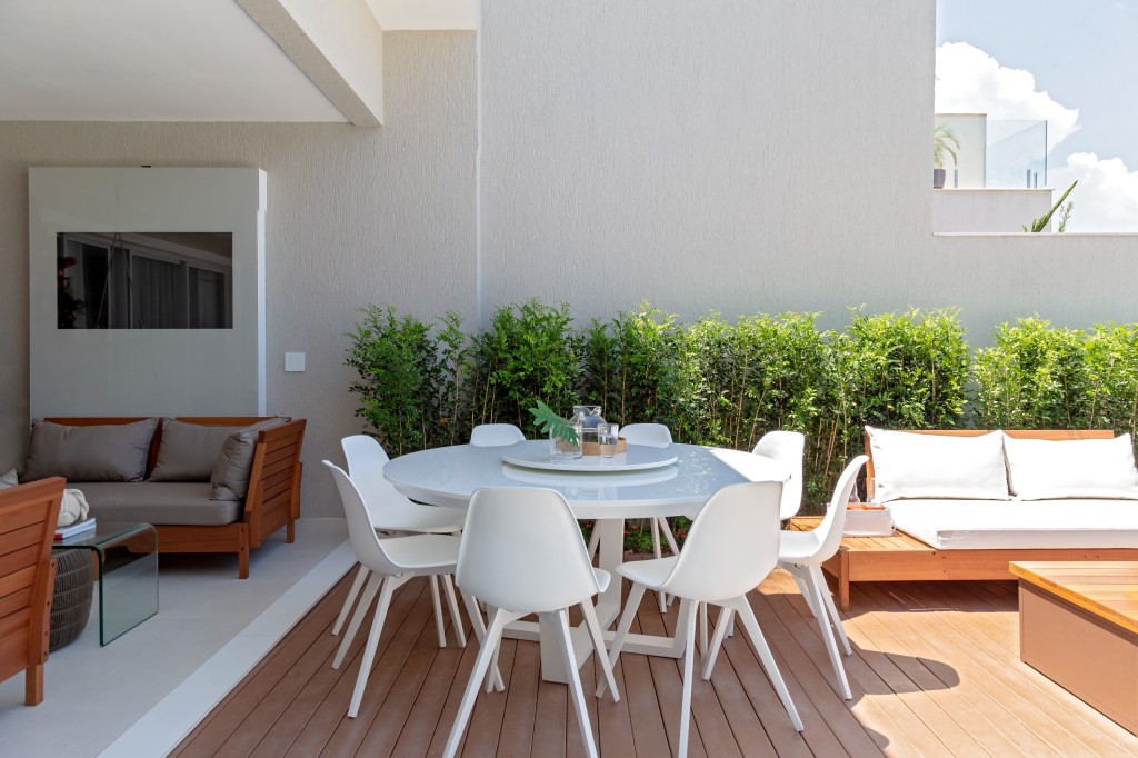 Pastilhas de inox e tons neutros marcam o décor desta casa de 410 m², Projeto de Mari Coelho. Na foto, varanda com estar e jantar,