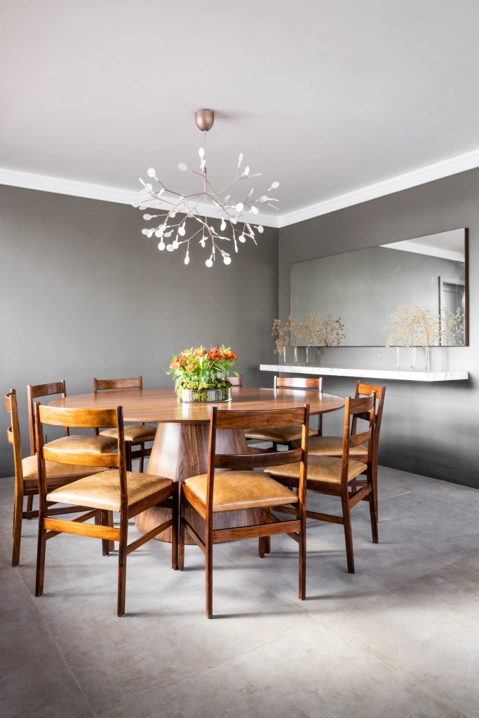 Peças garimpadas marcam o décor sofisticado deste apartamento de 370 m². Projeto de Renata Patelli. Na foto, sala de jantar com lustre e mesa redonda.