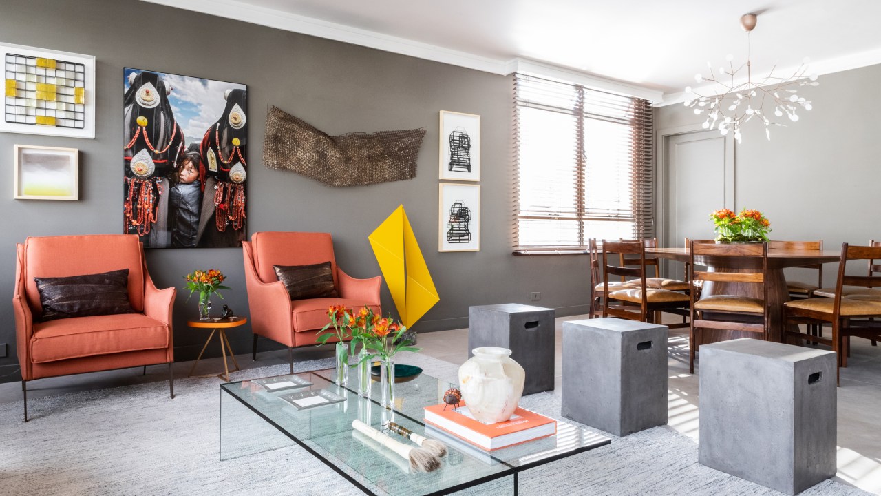 Peças garimpadas marcam o décor sofisticado deste apartamento de 370 m². Projeto de Renata Patelli. Na foto, sala de estar com sofá cinza e obra de arte.