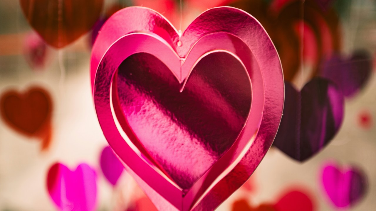 5 simpatias para atrair um amor no Carnaval. Na foto, enfeite de coração de papel rosa pendurado.