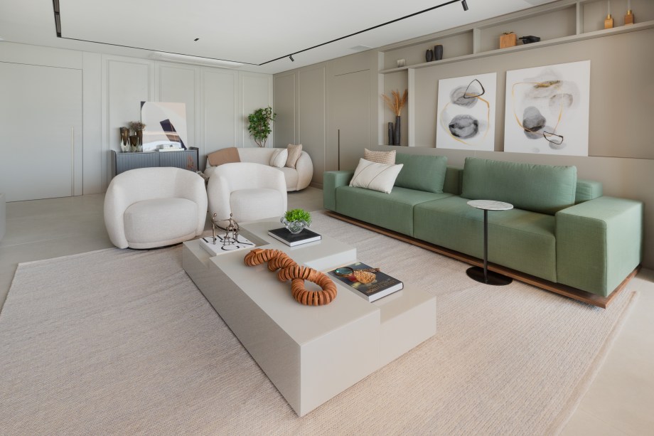 Sofá verde inspira a paleta de cores deste apartamento com décor clássico