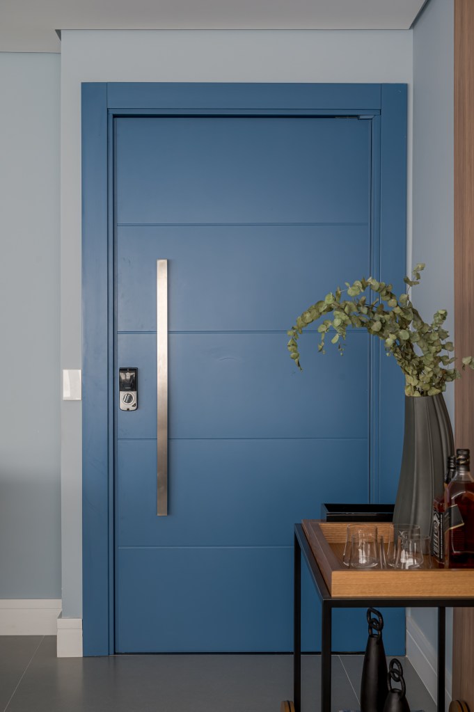 Tons de azul e integração total na área social marcam apê de 107 m². Projeto de Daniela Funari. Na foto, porta de entrada azul.