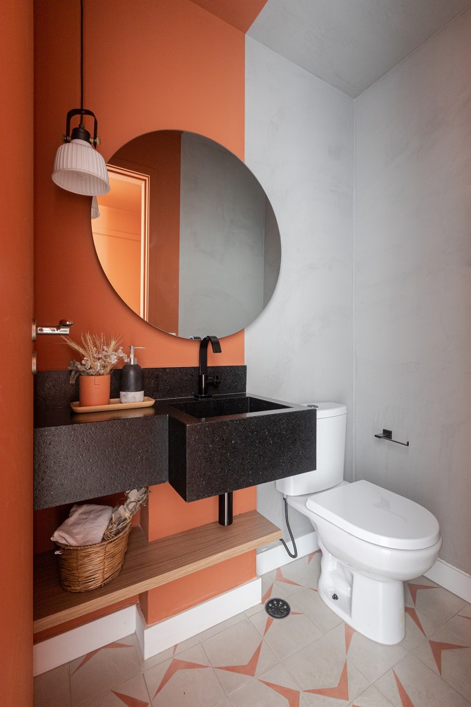 Uma única bancada une área gourmet e cozinha neste apê de 90 m². Projeto de Livia Dalmaso. Na foto, lavabo com espelho e ladrilho hiradulico.