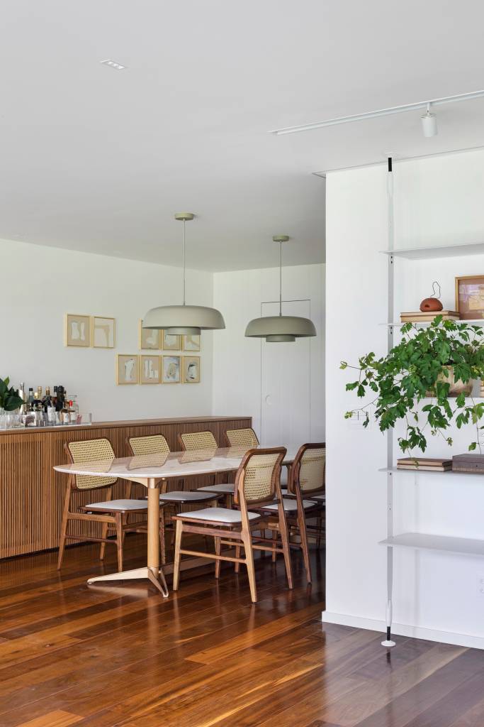 Apê integrado ganha décor contemporâneo com muita marcenaria em freijó. Projeto de João Panaggio. Na foto, sala de jantar, cadeira com encosto de palhinha, buffet.