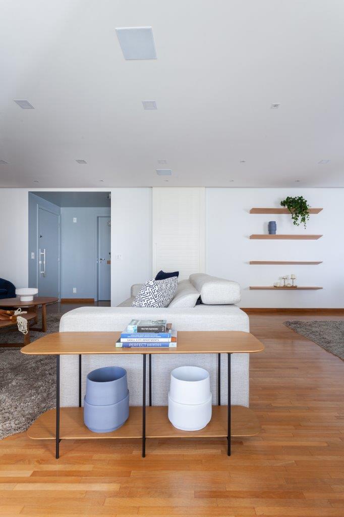Base neutra com pontos marcantes em azul definem apê de 167 m². Projeto de Ju Miranda. Na foto, sala de estar, sofá branco, mesa lateral com vasos.