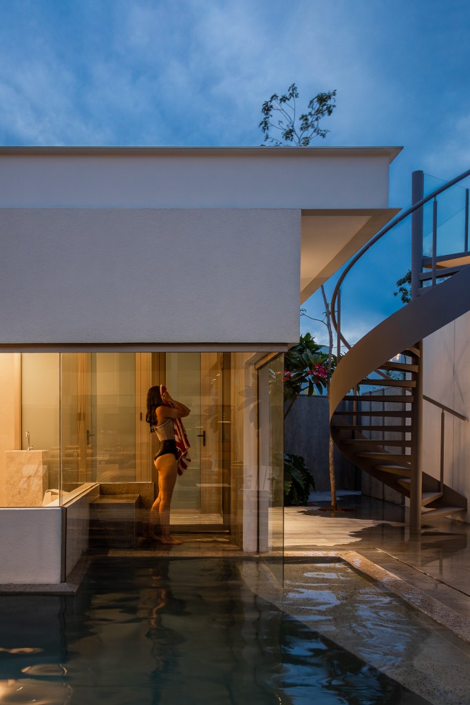 Casa de 168 m² em terreno triangular possui duas partes com usos distintos. Projeto de Studio Porto. Na foto, varanda com piscina. Sauna e escada.