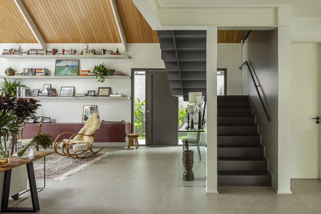 Casa de 415 m² com mezanino e varanda gourmet é inspirada em chalé alemão. Projeto de Arkitito Arquitetura. Na foto, sala, escada.
