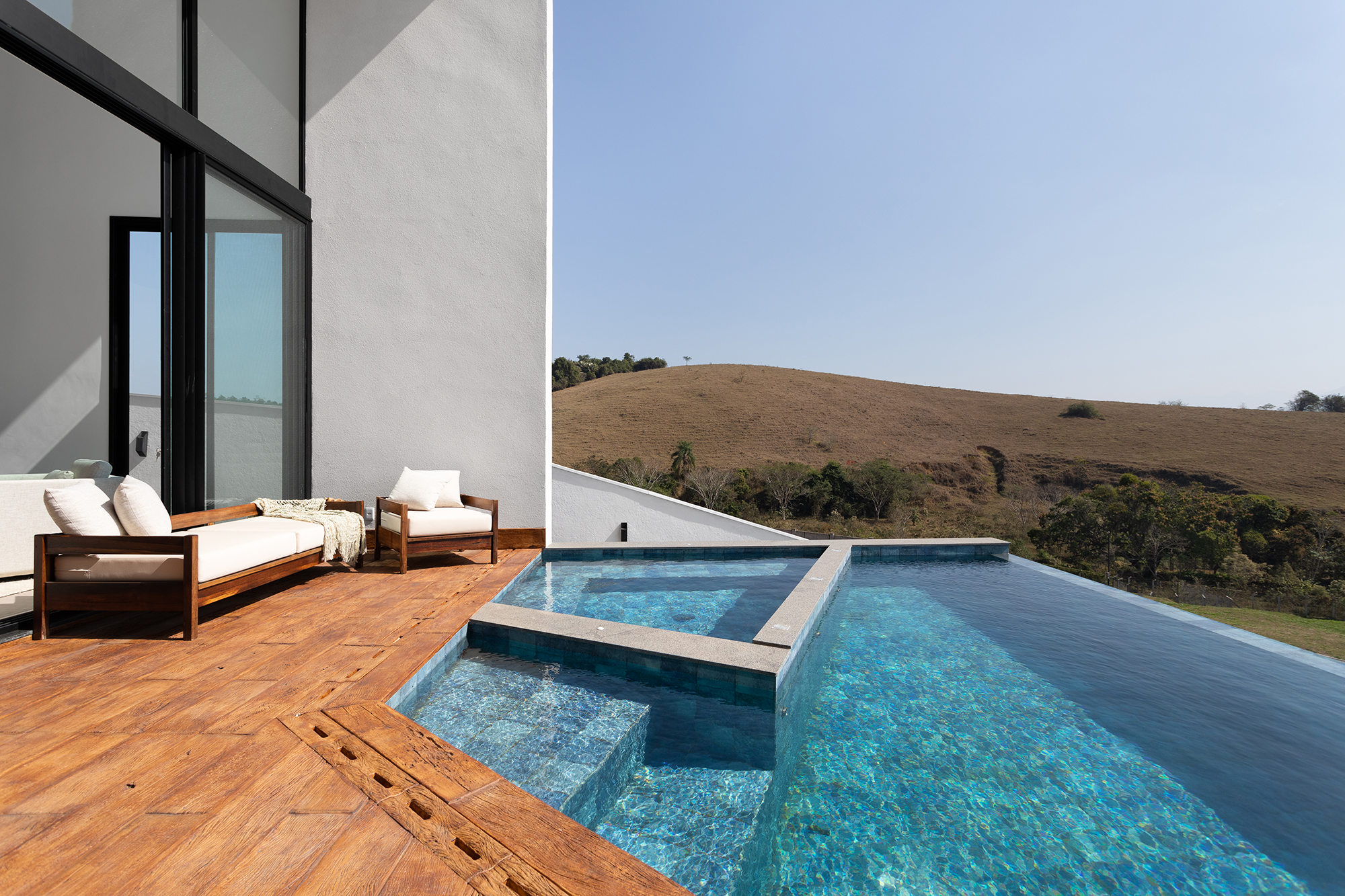Casa de 435 m² com vista para a Serra possui piscina em formato diagonal. Projeto de Vivi Cirello. Na foto, piscina com vista para a serra.