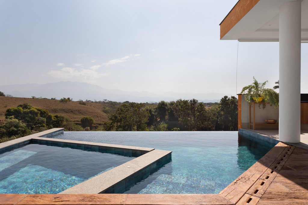 Casa de 435 m² com vista para a Serra possui piscina em formato diagonal. Projeto de Vivi Cirello. Na foto, piscina com vista para a serra.