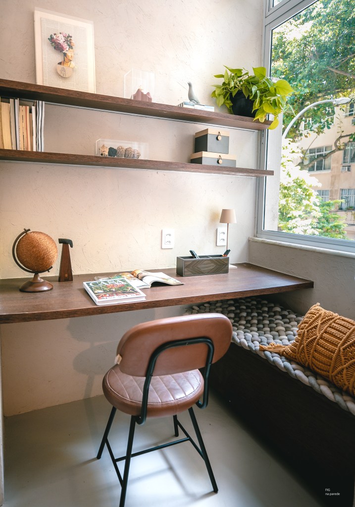 Com 33 m², studio com toque vintage usa tijolos de vidro como divisória. Projeto de Mariana Monnerat. Na foto, home office pequeno com bancada suspensa.