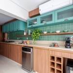Cozinha com armários e revestimentos verde azulados é o charme deste apê