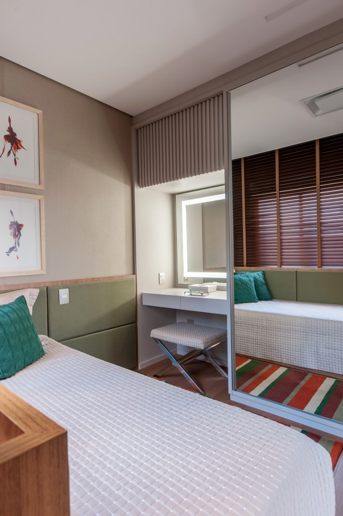 Cozinha com armários e revestimentos verde azulados é o charme deste apê. Projeto de Paiva e Passarini. Na foto, quarto com cama de solteiro, tapete listrado e penteadeira iluminada.