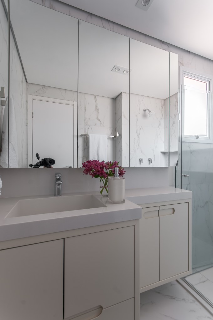 Cozinha com armários e revestimentos verde azulados é o charme deste apê. Projeto de Paiva e Passarini. Na foto, banheiro branco, armário espelhado.