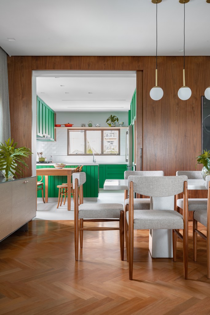 Cozinha verde, lavabo estampado e escorregador dão personalidade a apê. Projeto de Estúdio Pluri. Na foto, sala de jantar separada da cozinha por porta de correr.