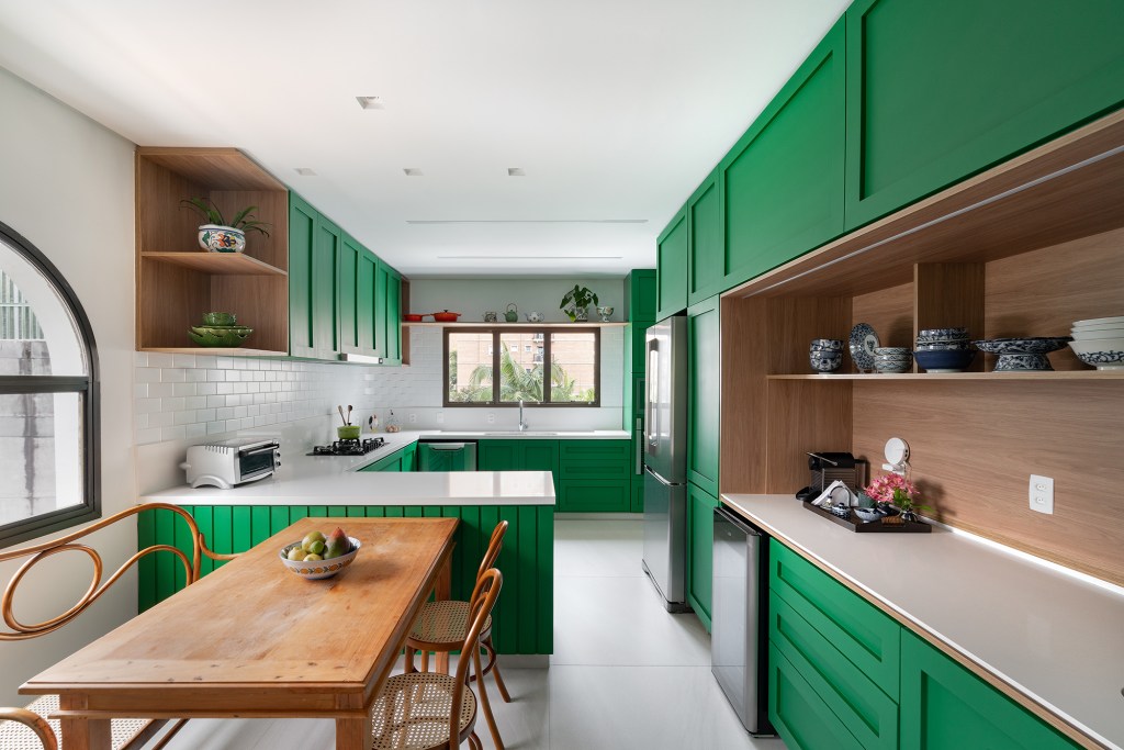 Cozinha verde, lavabo estampado e escorregador dão personalidade a apê. Projeto de Estúdio Pluri. Na foto, cozinha verde com copa e canto do café.