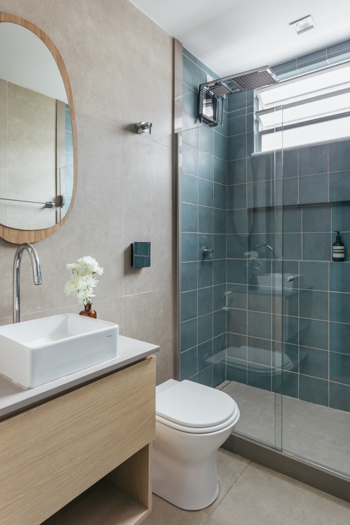 Microapê com 25 m² ganha tons azuis com reforma de apenas 3 meses. Projeto de Rodolfo Consoli. Na foto, banheiro pequeno, parede com azulejos azuis, cuba solta branca quadrada.