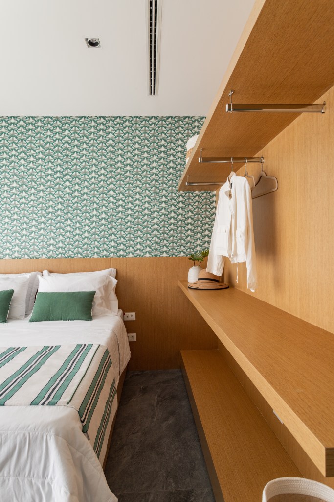 Mix de elementos artesanais, naturais e tecnologia definem casa de praia. Projeto de Patricia Penna. Na foto, quarto de casal com armário aberto, papel de parede.