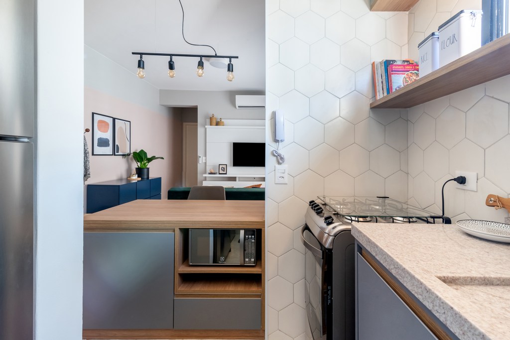 Sem grands intervenção, apê de 45 m² ganha cores e móveis multifuncionais. Projeto Abrazo Interiores. Na foto, cozinha integrada com balcão e revestimentos hexagonais.