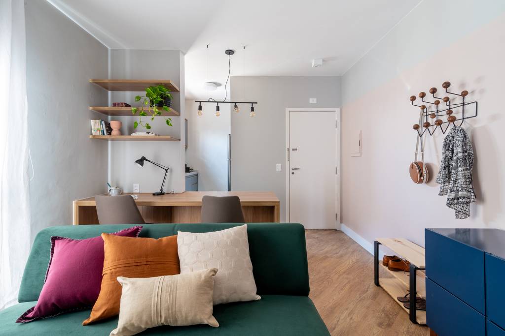 sem-grands-intervencao-ape-de-45-m²-ganha-cores-e-moveis-multifuncionais-abrazo-interiores-credito-julia-herman (3) Sem grands intervenção, apê de 45 m² ganha cores e móveis multifuncionais. Projeto Abrazo Interiores. Na foto, home office na sala integrado com a cozinha. Sofá verde.