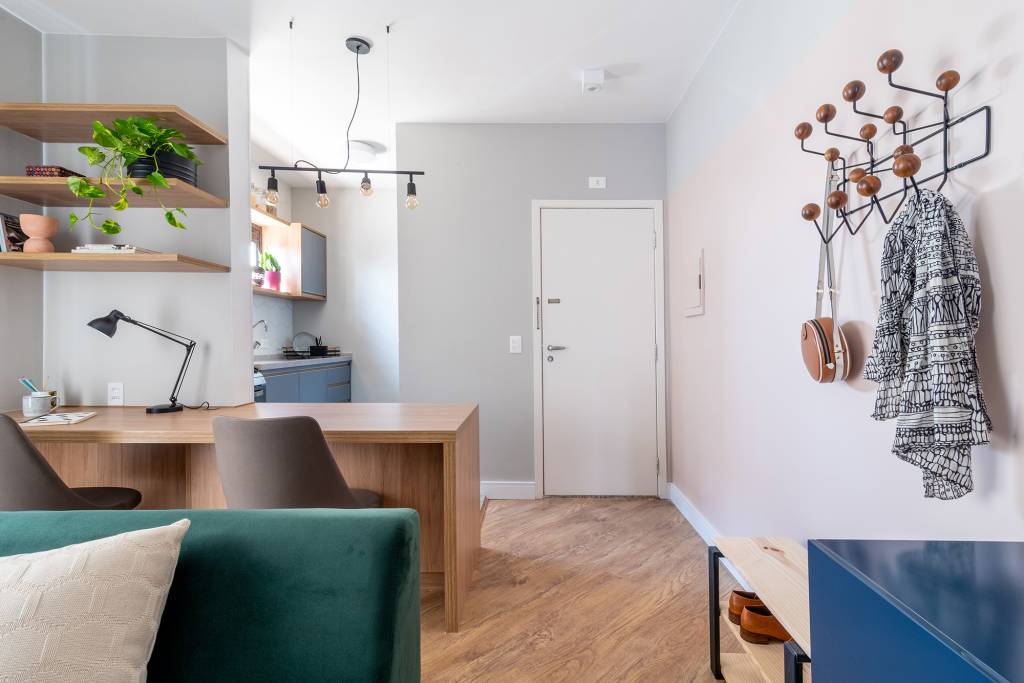 Sem grands intervenção, apê de 45 m² ganha cores e móveis multifuncionais. Projeto Abrazo Interiores. Na foto, home office na sala integrado com a cozinha.