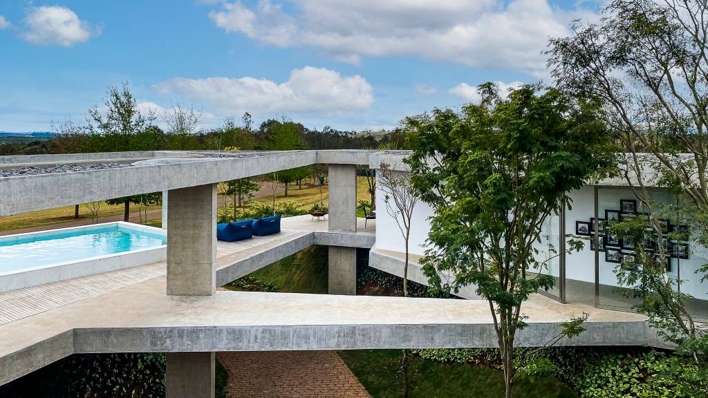 Vazios e passarelas fazem recortes no desenho desta casa de 485 m². Projeto de FGMF. Na foto, pátio com jardim e piscina.