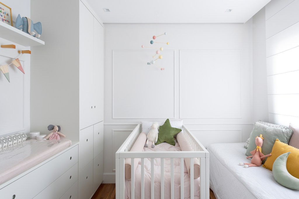 Apartamento de 151 m² ganha bar de mármore logo na entrada. Projeto de Ana Toscano Arquitetura. Na foto, quarto de bebê com berço e boiserie na parede.