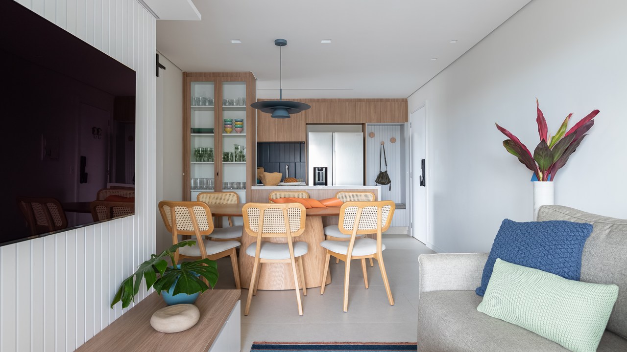 Apartamento de 83 m² ganha décor acolhedor sem derrubar nenhuma parede. Projeto do Estúdio Maré, Na foto, sala de estar a jantar com tv e mesa redonda.