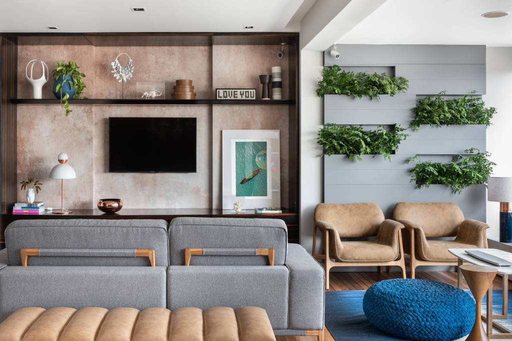 Beatriz Quinelato ARQ – AP Itaim @escanhuelaphoto @mayranavarro Apartamento ganha décor com tons de azul, cinza e madeira. Projeto de Beatriz Quinelato. Na foto, sala de TV com papel de parede e varanda com jardim vertical.