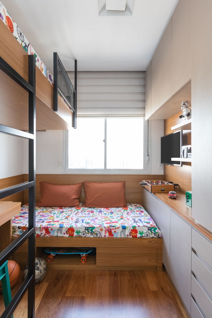 Apê de 120m² ganha cozinha integrada azul e sala de TV com porta de correr. Projeto de Carolina Gava. Na foto, quarto infantil pequeno.