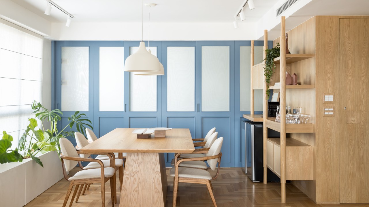 Apê de 180 m² ganha azul na marcenaria e nos revestimentos da cozinha. Projeto de Studio LAK. Na foto, sala de jantar, mesa de madeira, luminária branca, cadeiras brancas, porta de correr.
