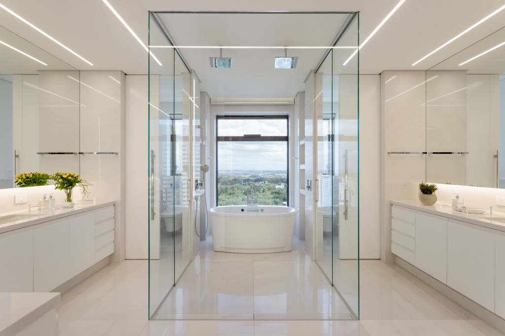 Apê de 580 m² ganha closet espelhado, área gourmet e hall marcante. Projeto de Andrea Teixeira. Na foto, banheiro branco com banheira de imersão.