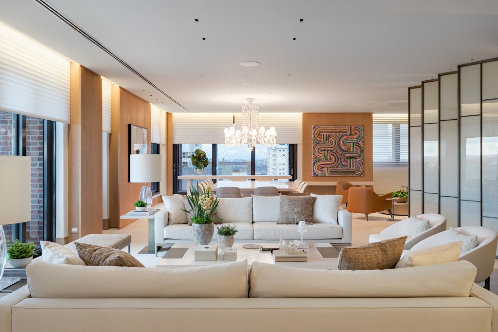 Apê de 580 m² ganha closet espelhado, área gourmet e hall marcante. Projeto de Andrea Teixeira. Na foto, sala de estar, sofás brancos, luminária.