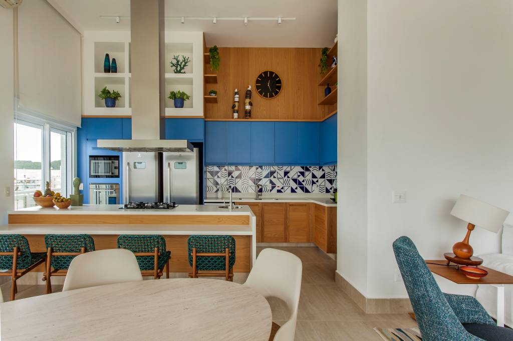 ape-decor-inspirado-praia-toques-azuis-e-porcelanato-areia-korman-arquitetos-01 Apê tem décor inspirado na praia com toques azuis e porcelanato areia. Projeto de Korman Arquitetos. Na foto, cozinha integrada, mesa de jantar oval, backsplash de azulejos.