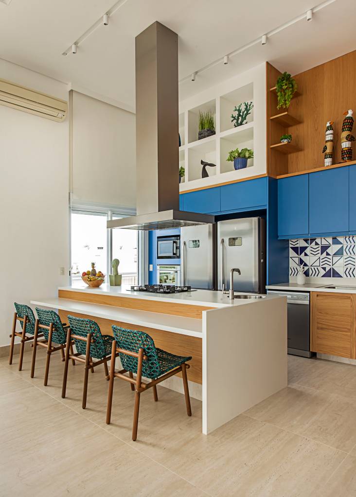 ape-decor-inspirado-praia-toques-azuis-e-porcelanato-areia-korman-arquitetos-05 Apê tem décor inspirado na praia com toques azuis e porcelanato areia. Projeto de Korman Arquitetos. Na foto, cozinha integrada com ilha e bancada brancas, banquetas.