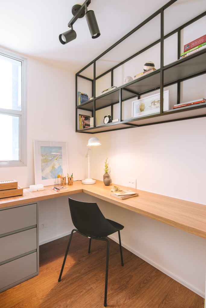 Apê industrial de 75 m² tem cozinha verde menta com bancada de cimento. Projeto de Rawi Arquitetura + Design. Na foto, home office com bancada L, armário suspenso preto vazado.