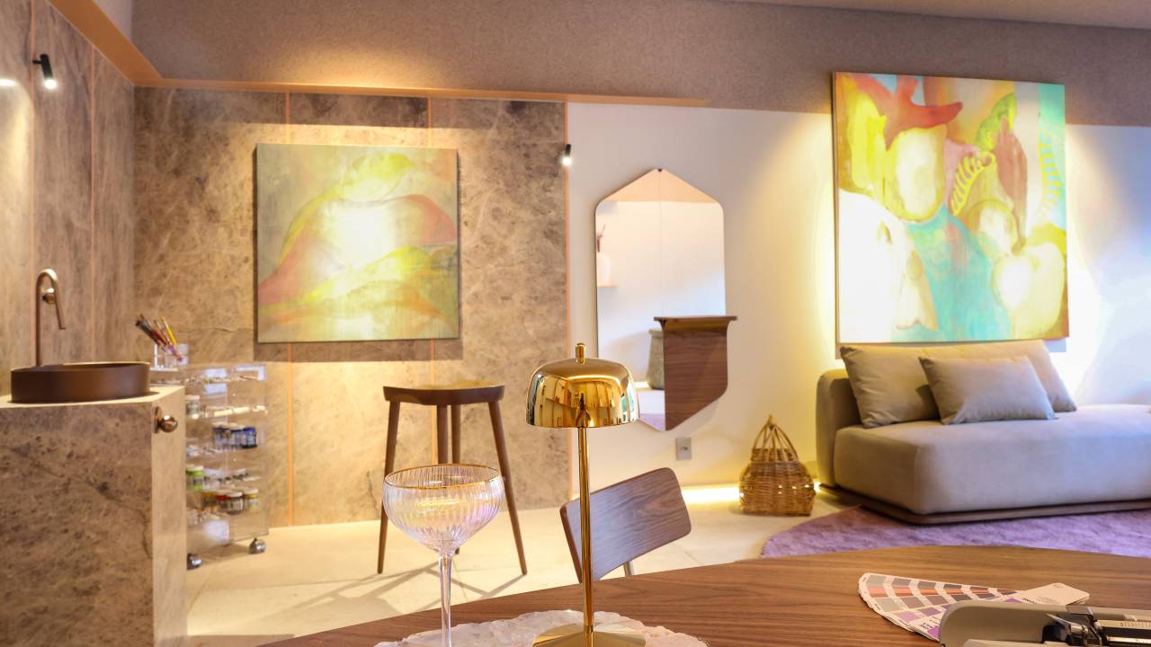 Ateliê tem parede com placas de quartzito, sala íntima e home office.