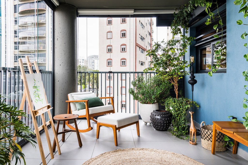 Azulejos estampados e cores trazem personalidade a apê de 100 m². Projeto de Carolina Munhoz. Na foto, varanda com banco, plantas e parede azul.