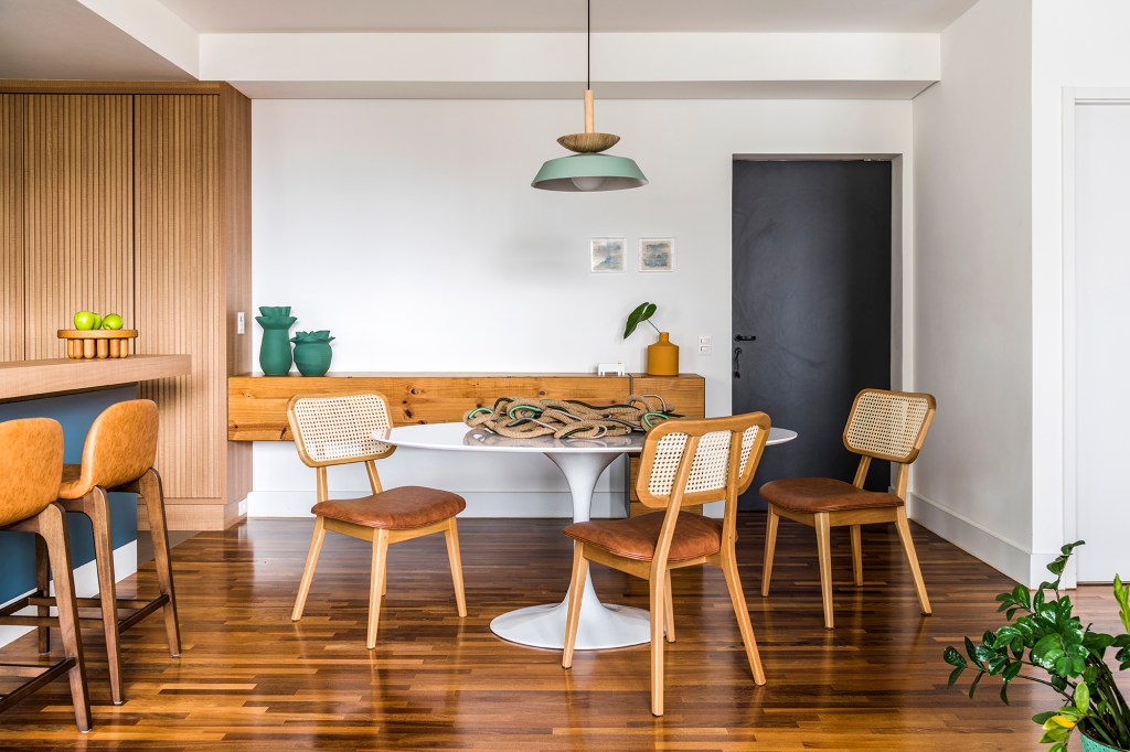 Azulejos estampados e cores trazem personalidade a apê de 100 m². Projeto de Carolina Munhoz. Na foto, sala de jantar com mesa circular, aparador e porta.