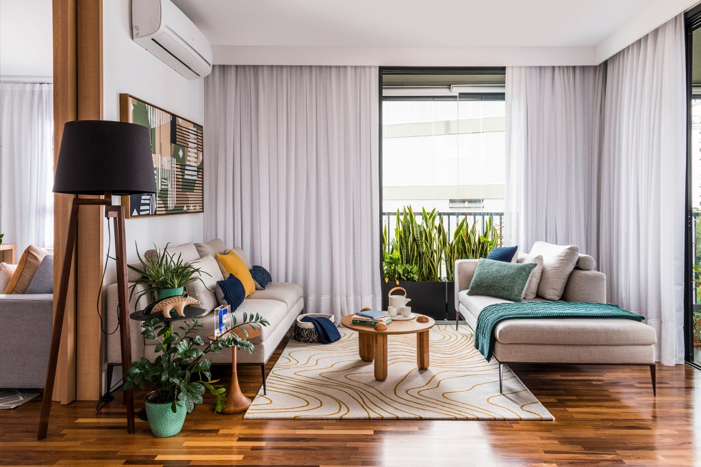 Azulejos estampados e cores trazem personalidade a apê de 100 m². Projeto de Carolina Munhoz. Na foto, sala com dois sofá, abajur e varanda.